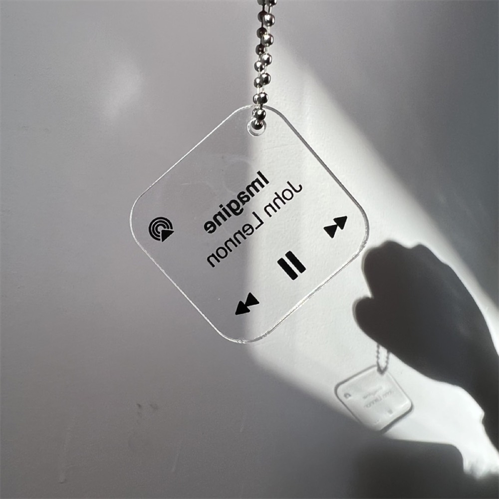 Transparent acrylic keychain with a printed music-player design on a ball chain