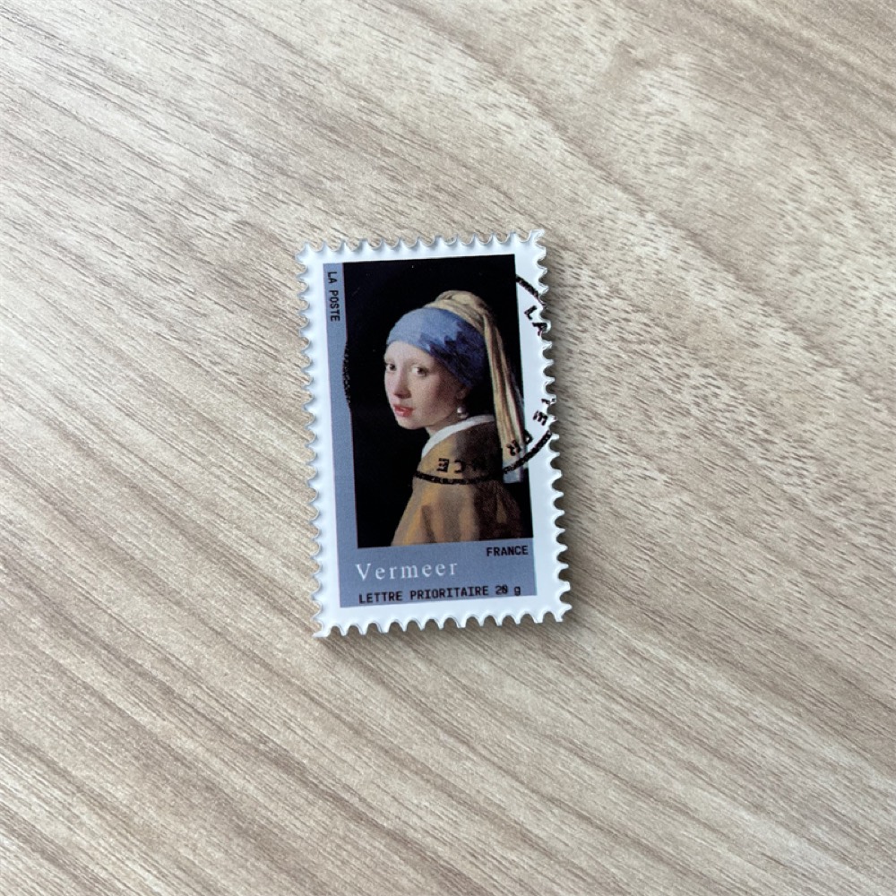 Fridge magnet shaped like a perforated postage stamp printed with a Vermeer painting