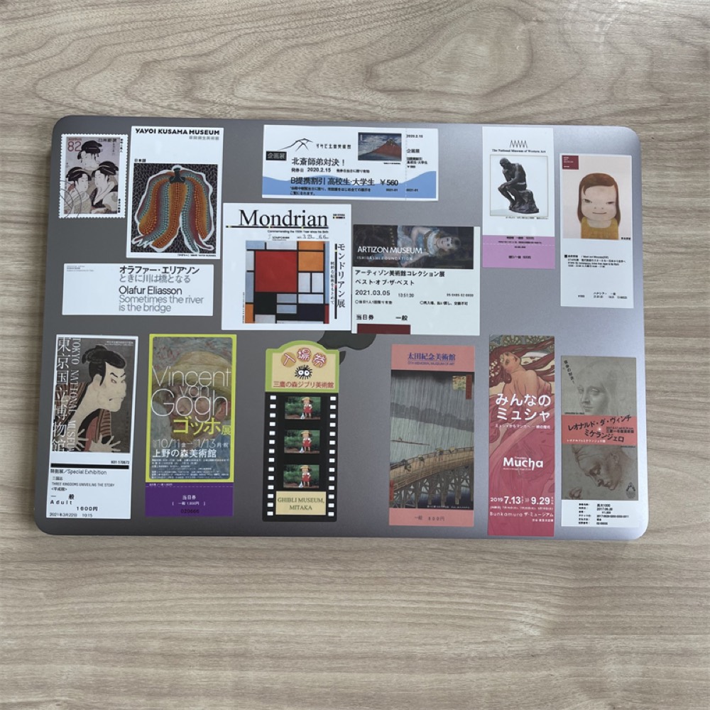 Laptop lid covered with museum-poster fridge magnets of different sizes